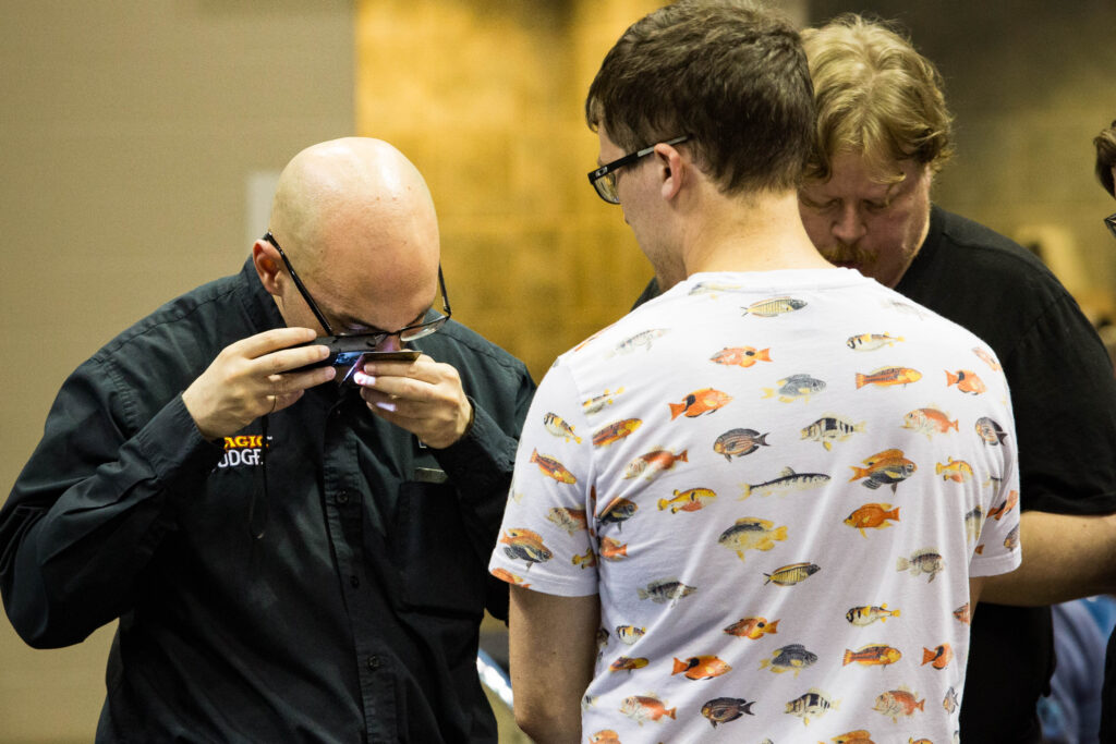 Steet examines a card with a loupe at MagicFest Indianapolis in 2019. Photo © John Brian McCarthy